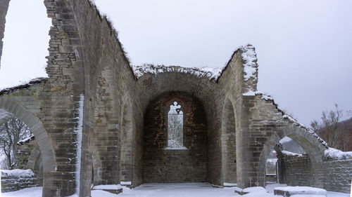 Snow covered old building against sky