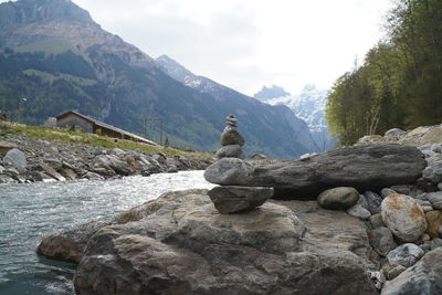 Stack of rocks by mountain against sky