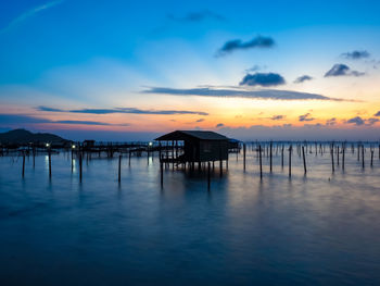 Pier on sea against sky during sunset