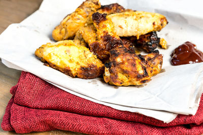 Close-up of chicken wings with sauce on folded fabric