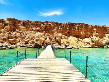 Pier over sea against blue sky