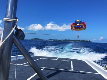 Person parasailing in sea against sky