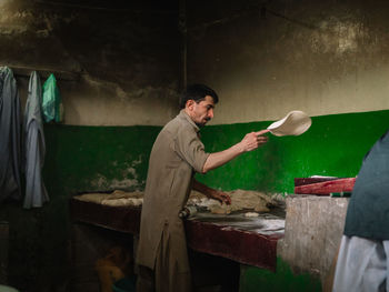 Man preparing chapatti in kitchen