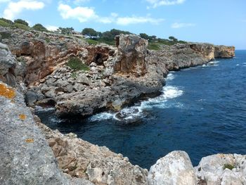 Rock formations by sea against sky