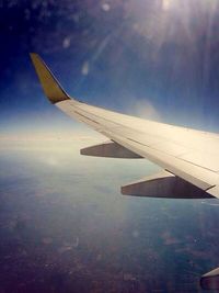 Cropped image of airplane flying over clouds