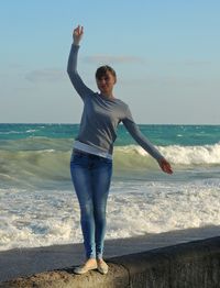 Full length of young woman standing on beach