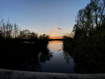 Scenic view of lake against sky at sunset