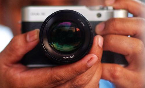 Cropped hand holding camera