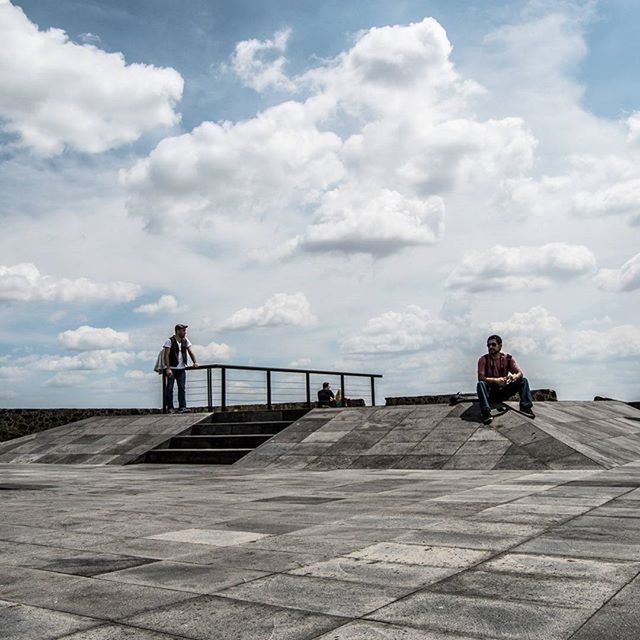 sky, cloud - sky, lifestyles, men, rear view, leisure activity, sea, full length, person, sitting, water, bench, cloud, horizon over water, cloudy, railing, tranquility