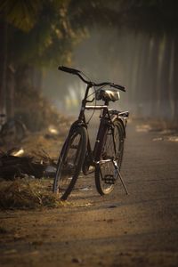 Bicycle parked on road during foggy weather