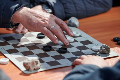 Midsection of man playing chess on table