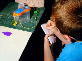 High angle view of man holding paper on table