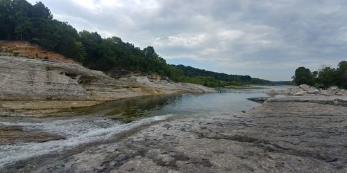 Scenic view of river amidst rocks against sky