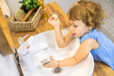 High angle view of girl playing with vegetables on table