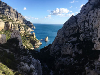 Scenic view of sea and mountains against sky