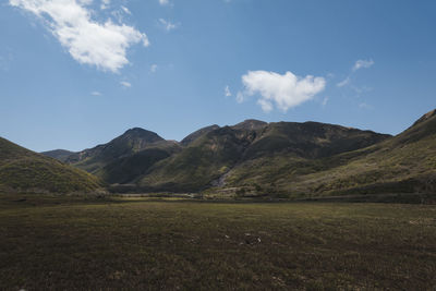 Scenic view of field and mountains against sky