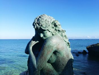 Statue of sea against clear blue sky