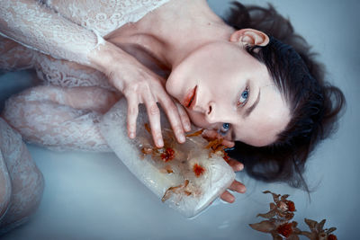 Icy flower - selfportrait - woman in icy water holding a flower in her hands