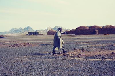 Rear view of a man walking on desert