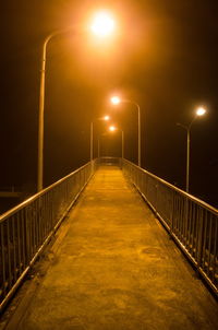 Illuminated street light against sky at night