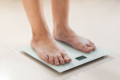 Low section of woman checking weight