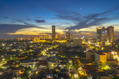 High angle view of illuminated buildings against sky at night