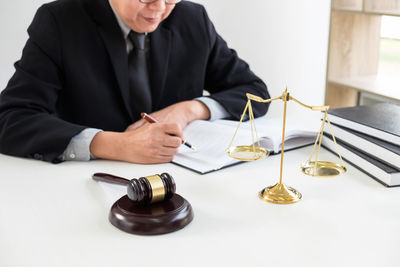 Midsection of lawyer working on desk