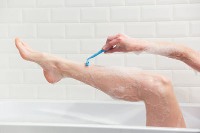 Midsection of person in bathroom at home