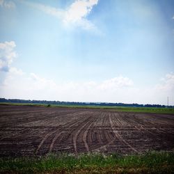 Scenic view of field against cloudy sky