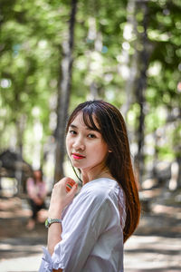 Portrait of beautiful woman against trees