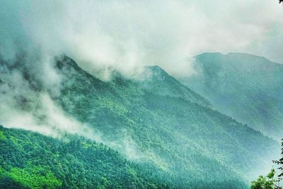 Scenic view of mountains against cloudy sky