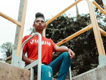 Full length of boy sitting on slide at playground