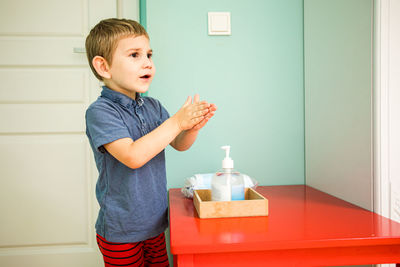 Boy applying hand sanitizer