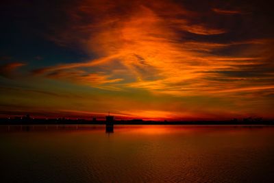 Scenic view of sea against dramatic sky during sunset