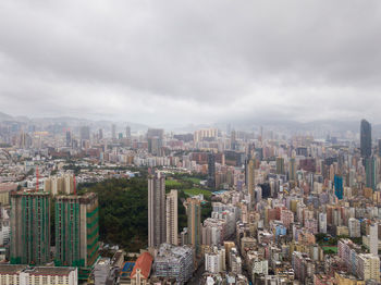 Aerial view of cityscape against cloudy sky