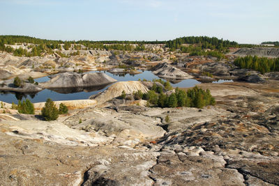 View on a flooded quarry with lakes and dried hills with rare vegetation.