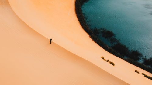 Drone view of sand dune against lake