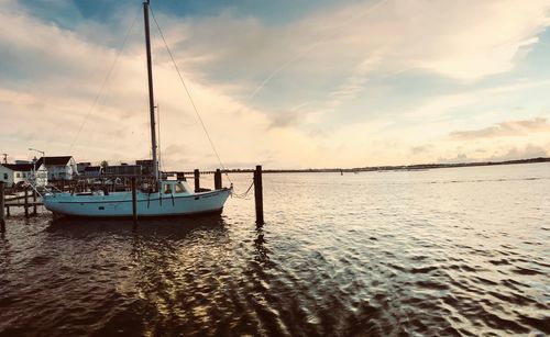 Sailboats in sea against sky during sunset