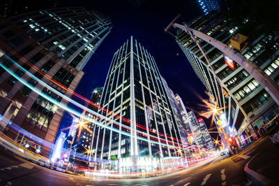 Low angle view of illuminated skyscrapers against sky at night