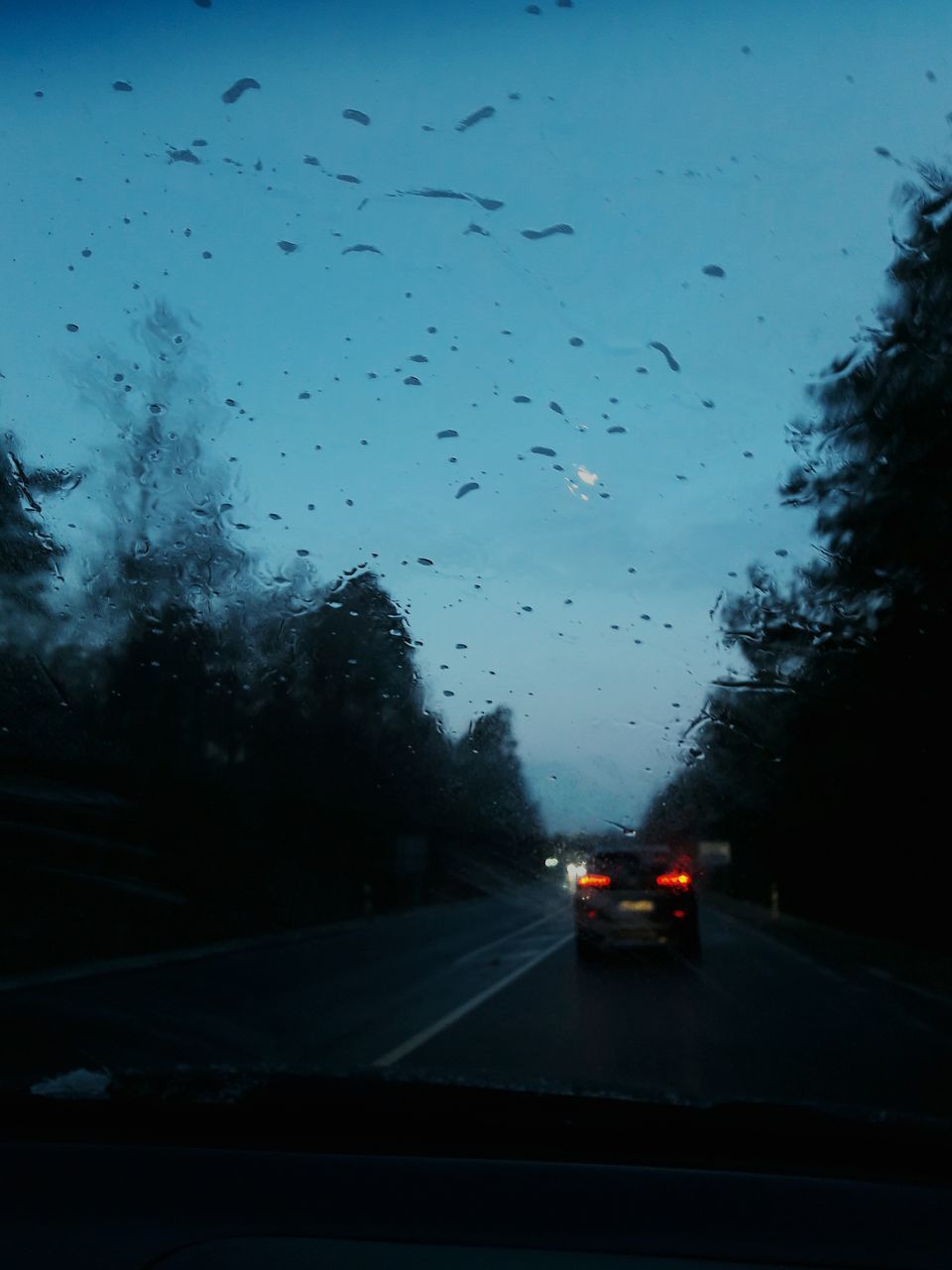 CARS MOVING ON ROAD AGAINST SKY