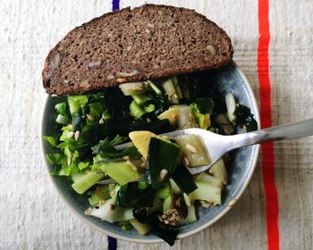 Directly above shot of salad and bread served in bowl on table