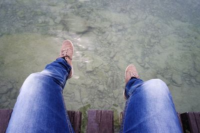 Low section of men sitting by water