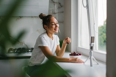 Beautiful young woman nutritionist conducts an online video call via smartphone with a friend