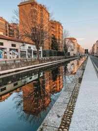 Bridge over canal in city against sky