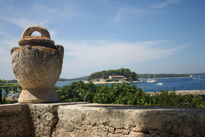 Close-up of retaining wall by sea against sky