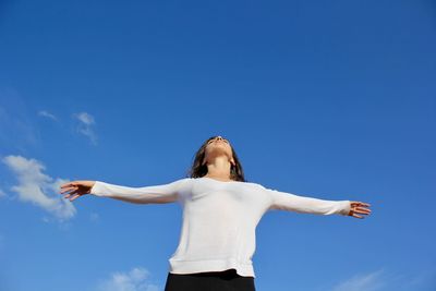 Low angle view of woman standing against sky