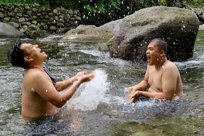 Shirtless boy splashing water