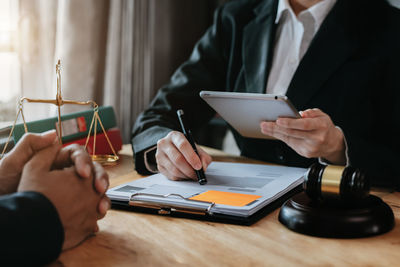 Midsection of lawyer talking with client