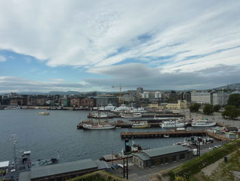 Boats in river against sky in city