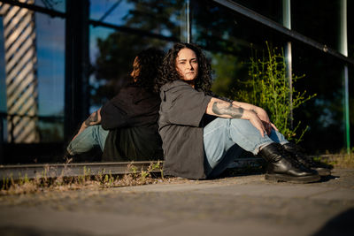 Portrait of young woman sitting on street